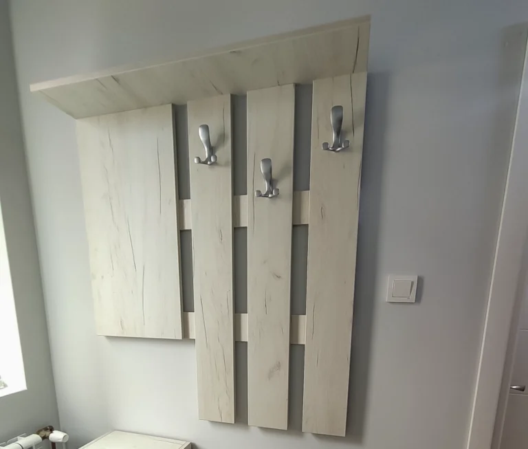 Завършено портманто от ПДЧ Дъб Крафт Бял с три куки, горен рафт, чекмедже и двукрилен шкаф.