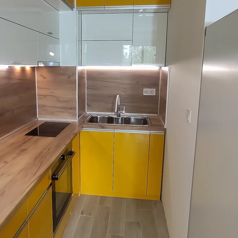 Близък план на мивката и жълтите фасади с гланцов ефект