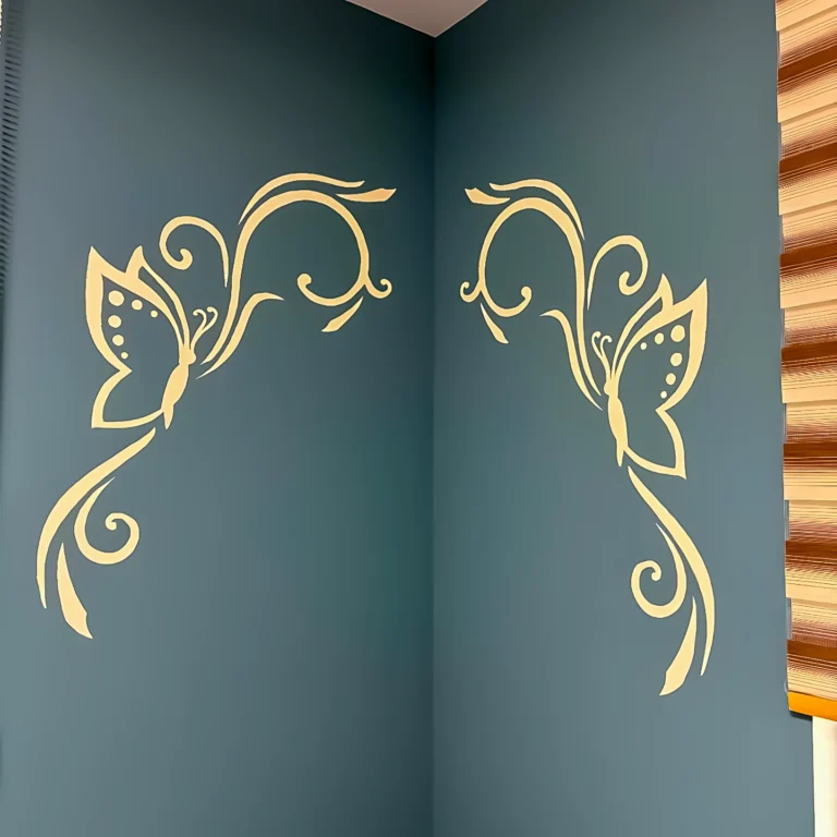 Декоративна стена в петролено зелено с огледални пеперуди и флорални елементи в ъгъла на дневната.