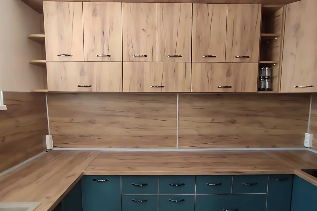 Централен изглед на кухнята с плавен контраст между дървесна текстура и наситени зелени фронтове.